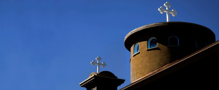 Church steeple with white christian cross with blue skyの写真素材
