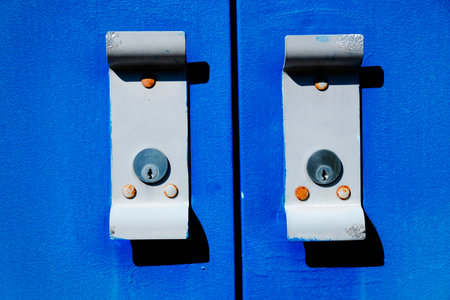 Old blue metal doors with handles worn textureの写真素材