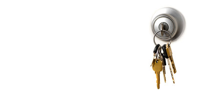 Keys in lock hanging from door knob doorknob for security and safetyの写真素材