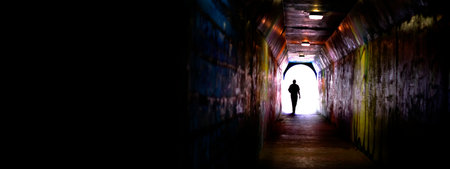 Single individual person at end of tunnel for success and triumph at end of journeyの写真素材