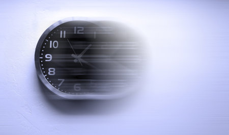 Detail of clock face with numbers and hands showing time with clock in motion for speed time flies...