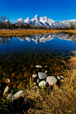 Tetons Tetons Mountain Range in Winter with snow and trees and reflection of light in Riverの写真素材