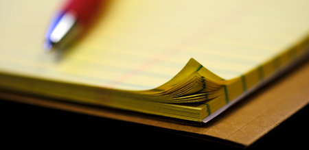 Notebook or legal pad with bent pages of paper worn edges dog earred cornerの写真素材