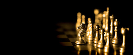 Pieces on chess board for playing game and strategy knight kingdom gaming golden chessの写真素材