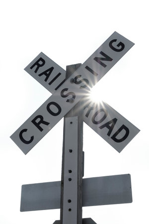 Railroad crossing sign with sunstar sunbeams for avoiding dangerの写真素材