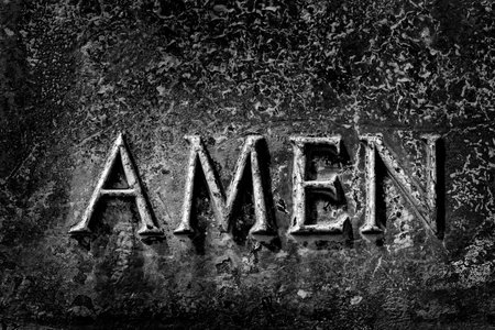 Prayer sculpture in bronze weathered metal with word Amen as end of prayingの写真素材