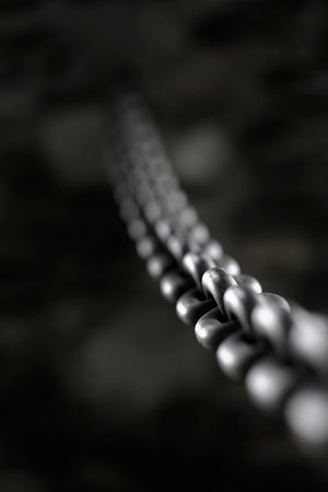 Detail of heavy steel or iron chain fastened into a rock wallの写真素材