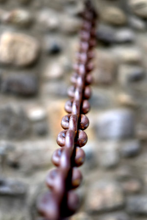 Detail of heavy steel or iron chain fastened into a rock wall