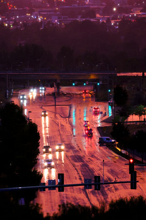 Traffic of cars driving on rainy night on wet road with lightsの写真素材