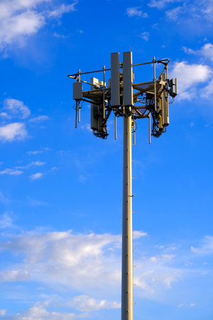 Signal tower for transmitting radion signals and communicating telecommunications with blue sky and cloudsの写真素材