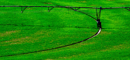 Irrigation pivot circle in lush green farm field with tracks on groundの写真素材