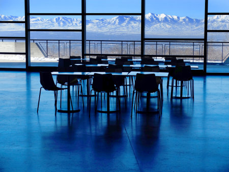 Empty business meeting room with tables and chairs and a window view of mountainsの写真素材