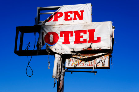 Detail of old torn and work or weatheres motel sign and blue sky vintage road travelの写真素材