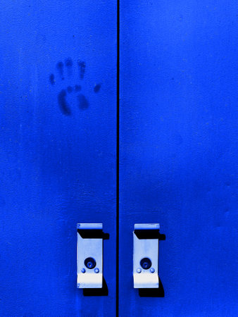 Detail of blue doors with handles and handprint hand print textureの写真素材