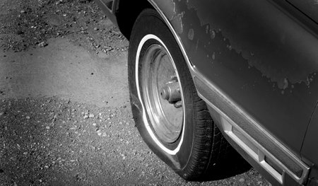 Flat tire red car vehicle deflated rubber wheelの写真素材