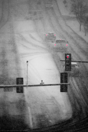 Cars and vehicles driving on road roadway in winter snow storm