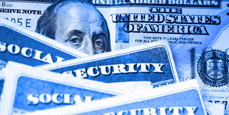 Several Social Security Cards on a US United States one hundred dollar bill $100 system of benefits for retired elderly peopleの写真素材