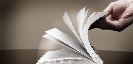 Book for reading and hand flipping pages looking at information searching and learningの写真素材