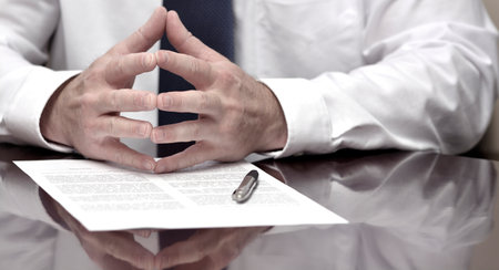 Businessman at desk with papers and contract making hand gesturesの写真素材