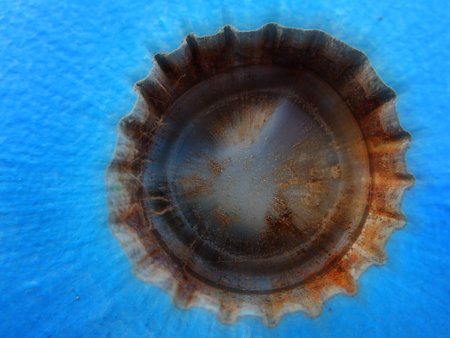 Closeup of old rusty bottle cap on blue background textureの写真素材