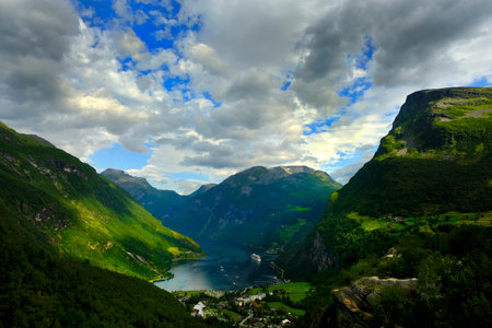 Detail of Norway Fjord Geiranger with lush green mountains around sea port and cloudy sky vacation cruise shipの写真素材