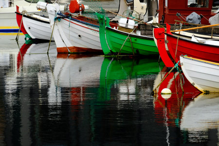 Detail of several colorful boats moored to docks reflectingin water with abstract reflectionsの写真素材