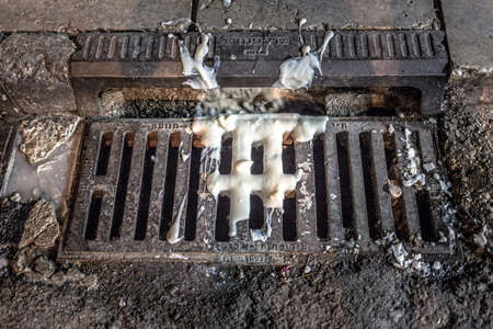 A manhole cover with a drain in the middle of the street.