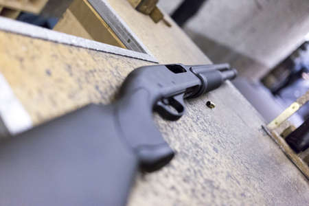 black shotgun on shooting range tableの写真素材