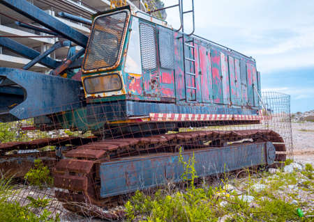 Abandoned old rusty excavator at a construction site