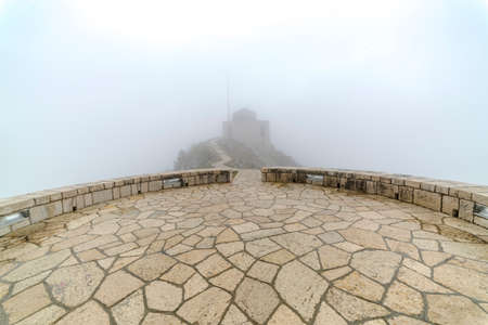 steep cloudy and misty mountains with stone footpath and platformの写真素材