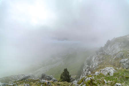 steep cloudy and misty mountains with stone footpath and platformの写真素材