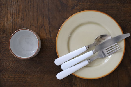 Empty plate with cutlery on wooden background. Top view.の写真素材
