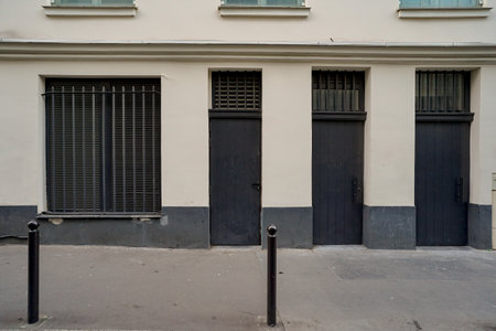 The entrance to the old house with a black iron door and a metal fenceの写真素材