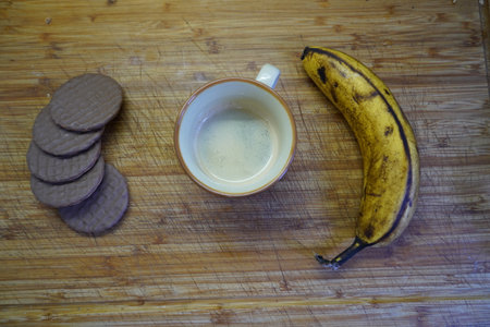 Cup of coffee with cookies and bananas on wooden background. Top viewの写真素材