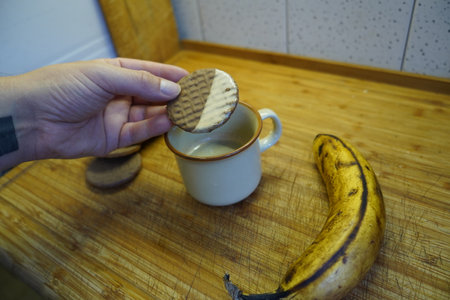 Cup of coffee with cookies and banana on a wooden table.の写真素材
