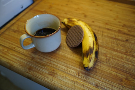 Cup of coffee with cookies and banana on a wooden table.の写真素材
