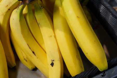 Bunch of bananas in a basket on a market stall, close upの写真素材