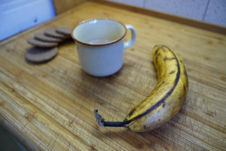 A cup of coffee and a banana on a wooden board. Selective focus.の写真素材