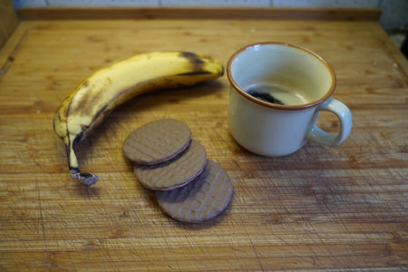 Cup of coffee with cookies and banana on a wooden background.の写真素材