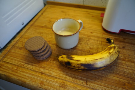 Cup of coffee, cookies and banana on a wooden table.の写真素材