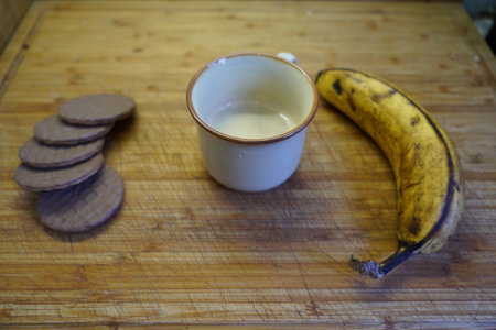 A cup of coffee and a banana on a wooden table. Selective focus.の写真素材