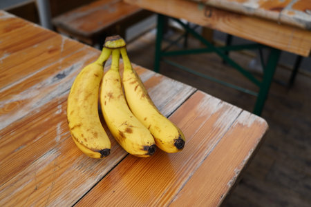 Bunch of bananas on a wooden table in a cafe, selective focusの写真素材