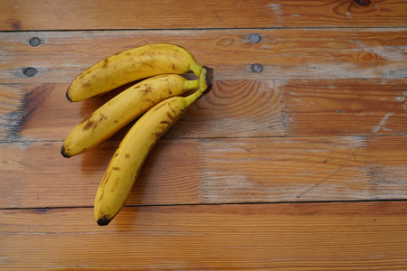 Bunch of bananas on a wooden table, top view, copy spaceの写真素材