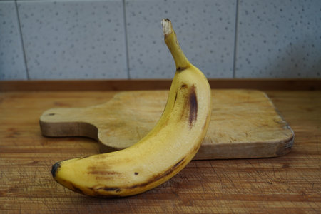 Banana on a cutting board on a wooden table in the kitchenの写真素材