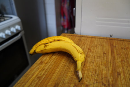 Banana on a wooden cutting board in the kitchen. Selective focus.の写真素材