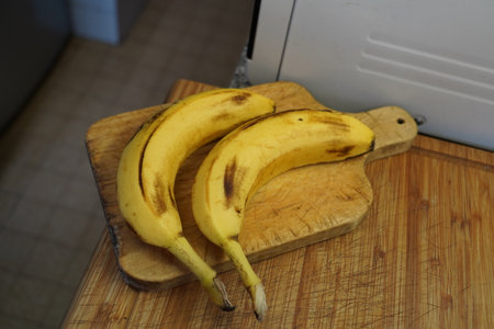Bananas on a chopping board in a kitchen. Selective focus.の写真素材