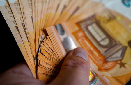 Fifty euro banknotes in hand on a dark background close up