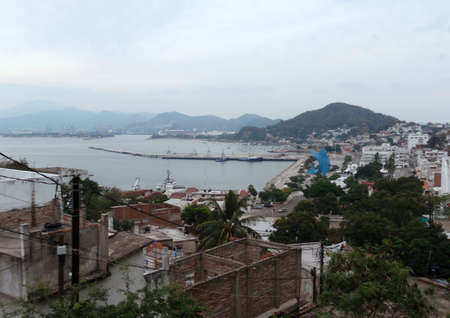 Manzanillo City and Harbor seen from the hills with iconic swordfish statue visible as well as several boating vehiclesの写真素材