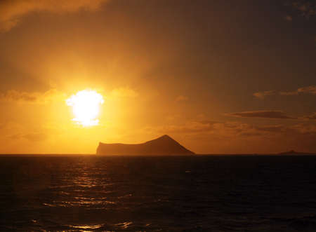Sunrise over small island off the Oahu coast in Hawaii    の写真素材