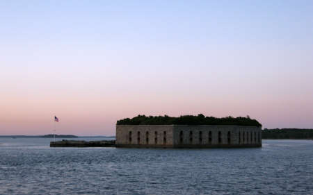 Historic Fort Gorges with American Flag waving at dusk in the harbor of Portland Maine.の写真素材